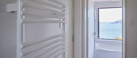 Un baño moderno con bañera y vistas al mar.