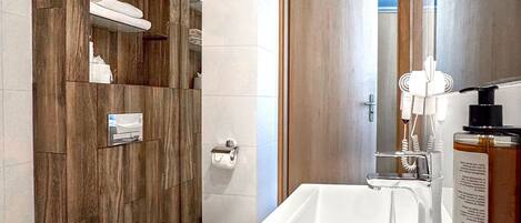 Un baño moderno con un mueble de tocador de madera, un inodoro y una bañera grande.