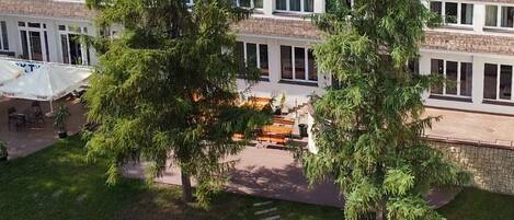 An aerial view of a building with a courtyard, surrounded by trees.