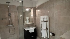 Une salle de bain moderne avec une douche à parois de verre, un lavabo blanc et des toilettes.