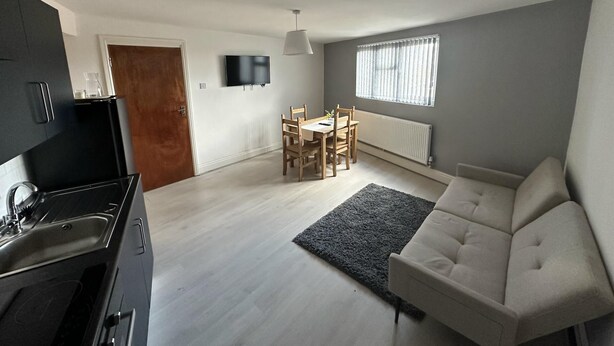 A modern apartment with a kitchen, dining area, and living room.