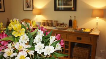 A room with a wooden cabinet, a vase of flowers, and wall-mounted lamps.