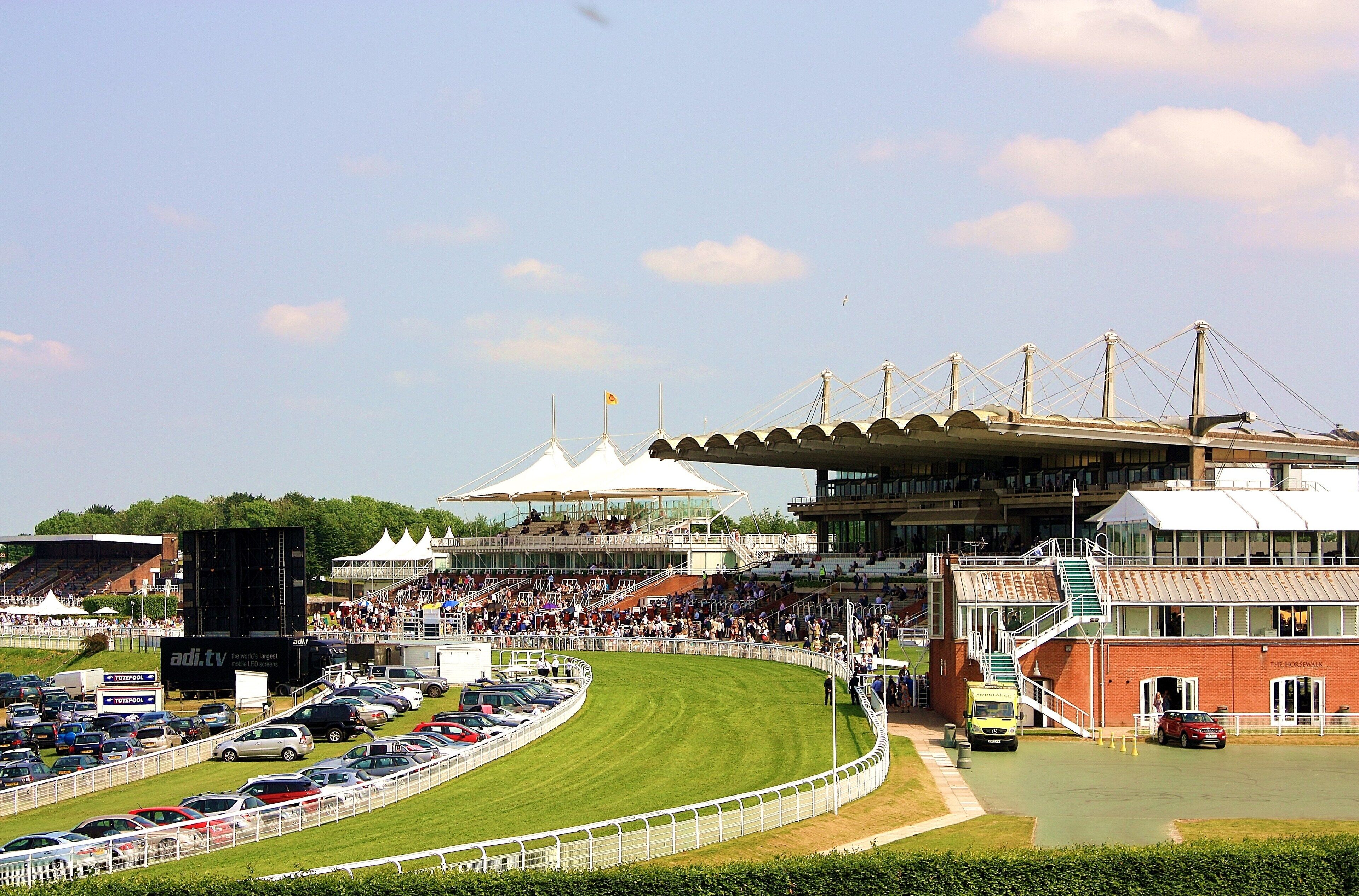 Un estadio grande con una zona de asientos techada y una pista para eventos de carreras.