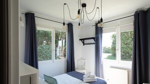 Une chambre à coucher avec un lit, une chaise, une fenêtre et un luminaire au plafond.