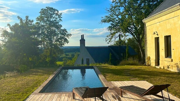 A swimming pool with two lounge chairs and a wooden deck. - Wunderschönes Landhaus Atemberaubende Aussicht (Huismes)