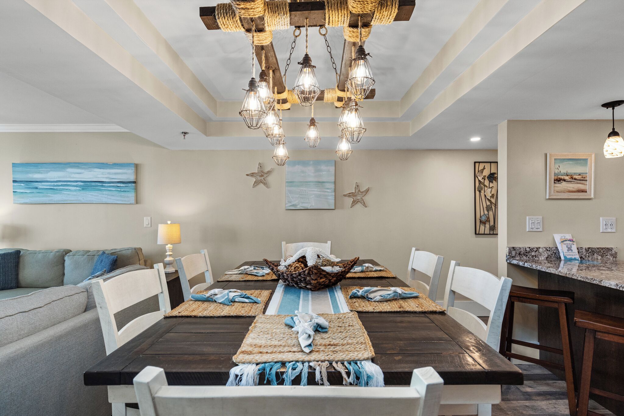 A dining area with a wooden table, white chairs, and a woven placemat.