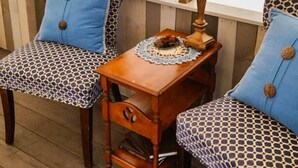 A cozy seating area with two patterned chairs, a small wooden table with a lamp, and a framed quote on the wall. - Glamping Tent! Nestled at base of Mission Mountains! Quiet & secluded.  (Ronan)
