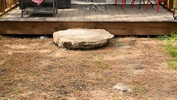 A cozy outdoor tent with a wooden deck, a sofa with cushions, and two red chairs. - Glamping Tent! Nestled at base of Mission Mountains! Quiet & secluded.  (Ronan)