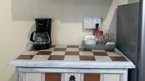 A kitchen with a checkered countertop, a coffee maker, a refrigerator, and a sink. - "Suite Serenity"- NEW Studio in PRIME location.10-minute walk to everything PV! (Puerto Vallarta)