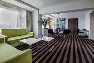 Business Studio Suite | Living area | 40-inch LCD TV with cable channels, books