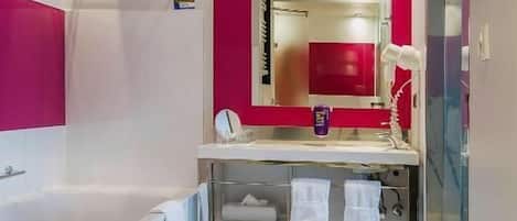 Un baño moderno con una bañera blanca, un tocador con espejo y una zona de ducha.