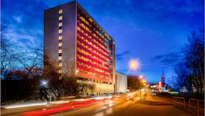 Un hôtel moderne doté d’une façade rouge imposante et de plusieurs étages.