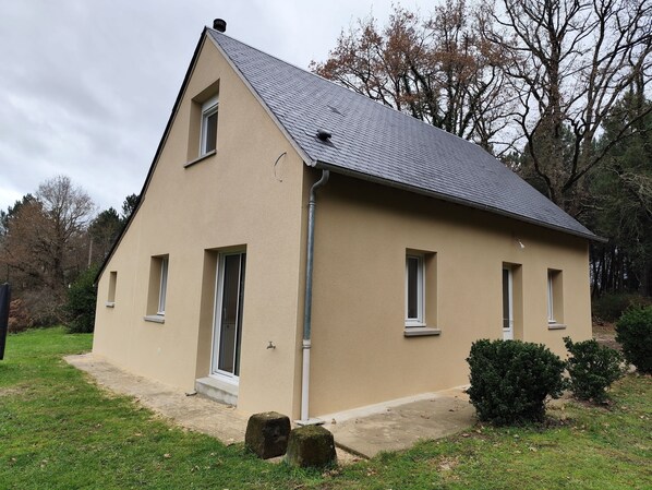 A single-story house with a sloped roof, a front door, and a small porch area.