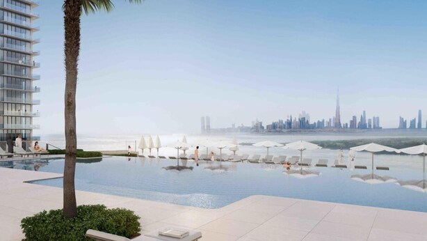 A modern hotel pool area with a city skyline view, lounge chairs, and a palm tree. - Comfortable 2BR Address Harbour Point (Dubai)