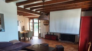 Una sala de estar con un sofá, una mesa de centro, una chimenea y una pantalla de televisión.