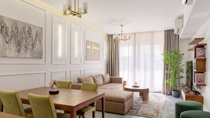 A modern living room with a dining area, a sofa, a coffee table, and a potted plant. - VESTA - New Cairo Residence (New Cairo)