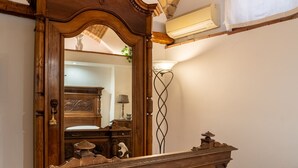 Ein Schlafzimmer mit einem großen Holzbett, einem Spiegel, einer Ziegeldecken und einem weißen Handtuch auf dem Bett.
