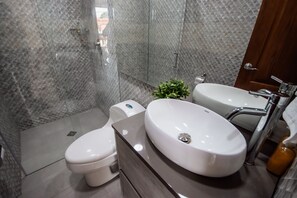 Deluxe appartement | Badkamer | Een douche, handdoeken, zeep, shampoo