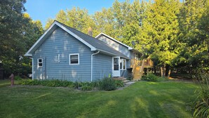 A two-story house with a covered deck and a well-maintained lawn. - Private 3-bedroom farmhouse in Rural Roseau (Roseau)