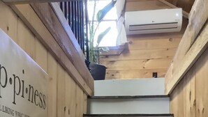Eine Holztreppe mit einem Schild, auf dem 'p·p·i·n·e·s·s' steht, und einem Blumentopf am oberen Ende.