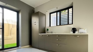 A modern kitchen with a built-in stove, a window with blinds, and a countertop with a coffee maker and a toaster. - Bayside (Marsaxlokk)