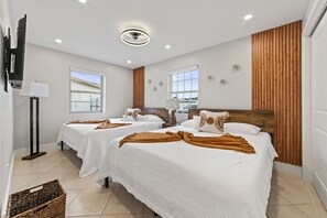 Une chambre d’hôtel avec deux lits, un ventilateur de plafond et une grande fenêtre.