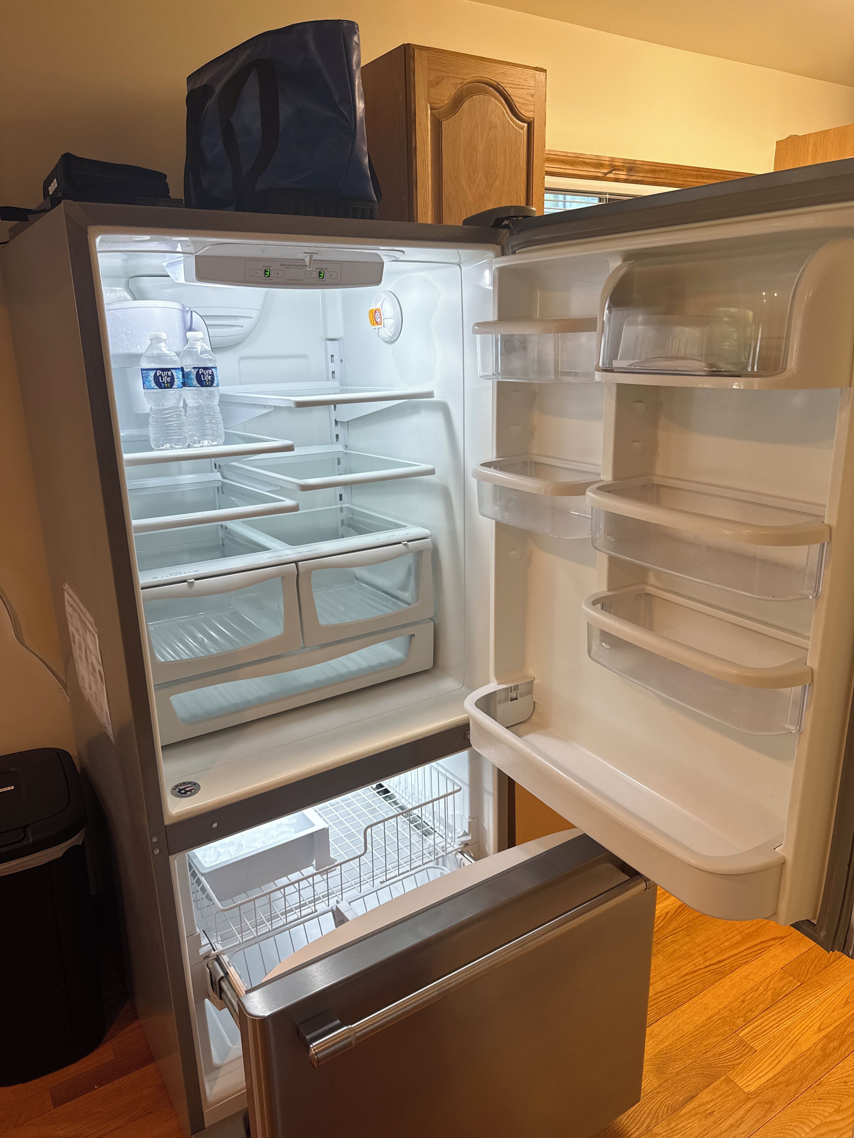 An open refrigerator with multiple shelves and a freezer compartment.