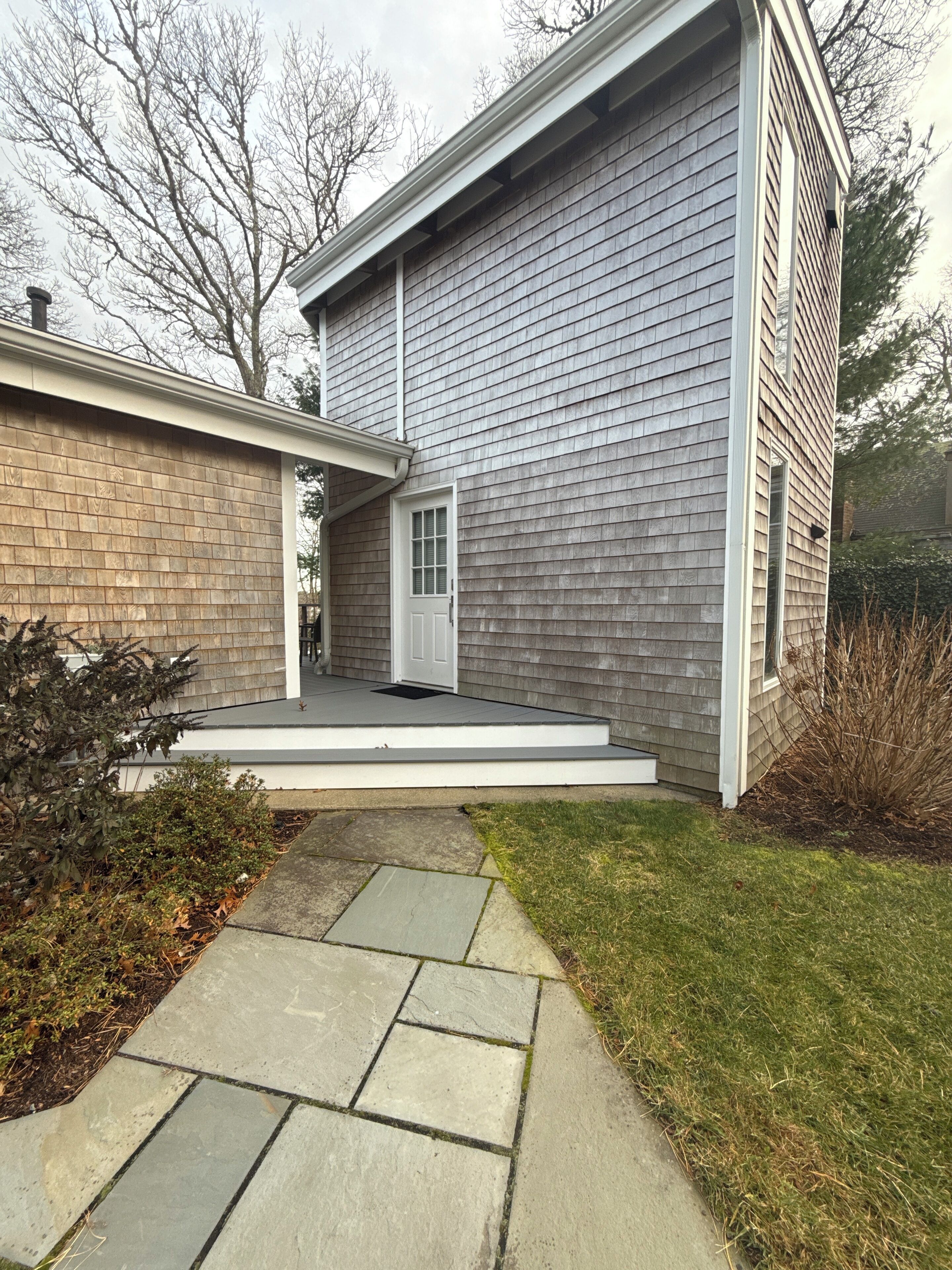 A modern two-story house with a stone pathway leading to the front door.