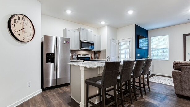 A modern kitchen with stainless steel appliances, a marble island, and bar stools. - A Traveler’s dream; Private Townhome 15min to Airport in peaceful Union City (Union City)