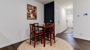 A dining area with a round table and chairs, a woven rug, and a painting on the wall. - A Traveler’s dream; Private Townhome 15min to Airport in peaceful Union City (Union City)