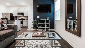 A modern living room with a sofa, coffee table, and a kitchen area in the background. - A Traveler’s dream; Private Townhome 15min to Airport in peaceful Union City (Union City)