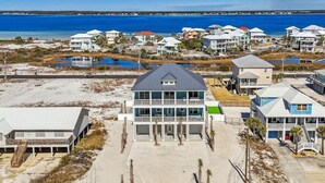 Un quartier résidentiel en bord de mer, avec des maisons modernes, une plage et une vue dégagée sur l’océan.