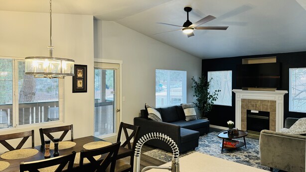 A modern living room with a dining area, a fireplace, and a ceiling fan. - Charming 2-BHK Condo, nestled in the heart of picturesque Leavenworth. (Leavenworth)