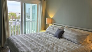 A bedroom with a large bed, a balcony, and a view of the outside. - Seaside Retreat - Shore Drive, 3 bed, 2.5 bathrooms with an Ocean View. (Horry County)