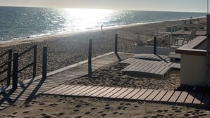 A beach with a wooden boardwalk leading to the water, a sandy area with footprints, and a clear sky. - Beach Front Condo ❤️ in Peaceful Las Conchas🌴 WiFi, Sleeps 8  (Puerto Penasco)