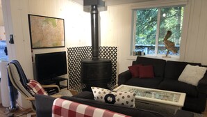 Un salon chaleureux avec une cheminée, un téléviseur et un coin salon confortable.