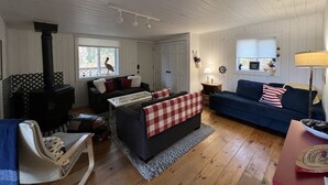 Un salon chaleureux avec une cheminée, deux canapés, une table basse et une table à manger.