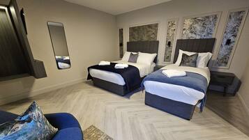 Ein Hotelzimmer mit zwei Betten, einem Sofa, einem Spiegel und Bildern an den Wänden.