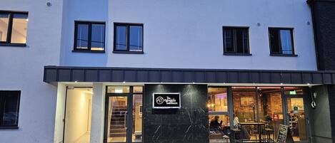 Un bâtiment moderne dont la façade comprend une vitrine avec une enseigne indiquant « The Atelier ».