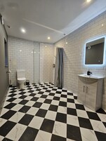 Habitación triple Grand | Baño | Ducha, suelo radiante, jabón y champú