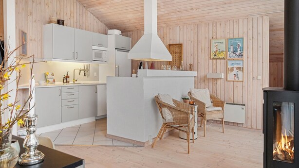 Une cuisine moderne avec des meubles blancs, un îlot central et une grande cuisinière.