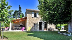 A stone house with a patio, outdoor seating, and a slide. - Le Mazet De Bious Sadous (Isle Sur La Sorgue)