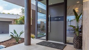 A modern building entrance with a glass door, a concrete pillar, and a potted plant. - Villa Aria with pool, 100m to beach (Tučepi)