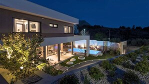 A modern two-story house with a swimming pool, outdoor seating, and a well-lit garden area. - Villa Aria with pool, 100m to beach (Tučepi)