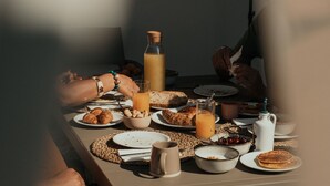 A dining table with various breakfast items, including toast, croissants, and a beverage. - METHE Resort (Lizzano)