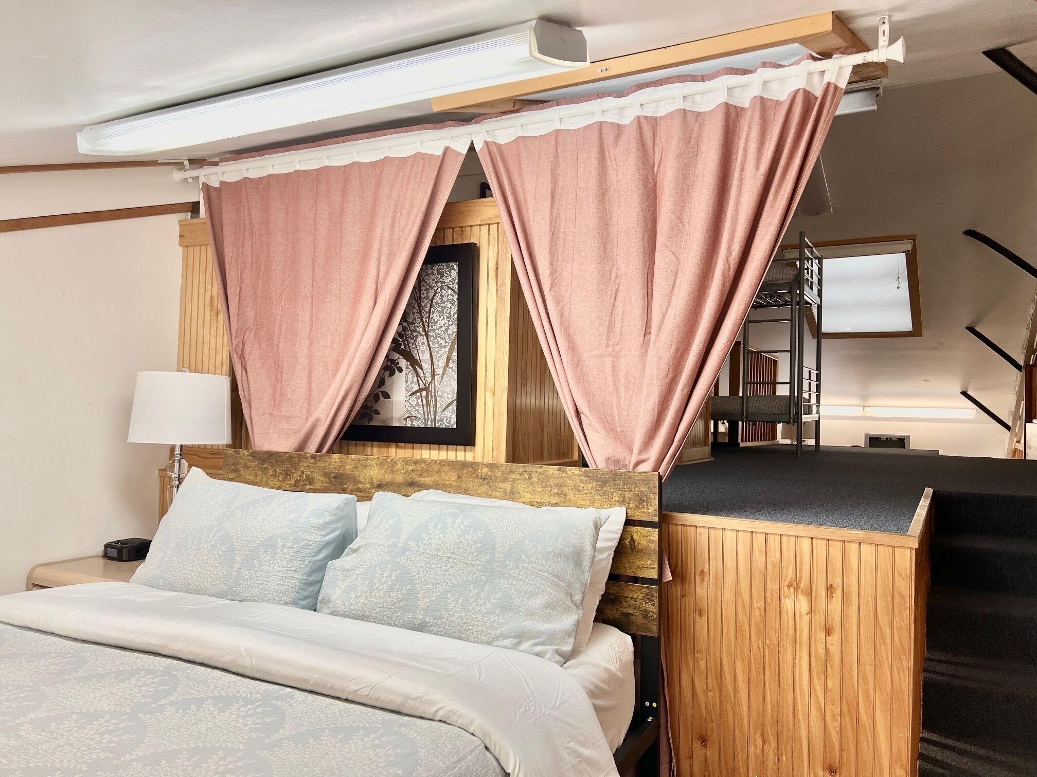 A hotel room with a bed, a desk, and a chair.