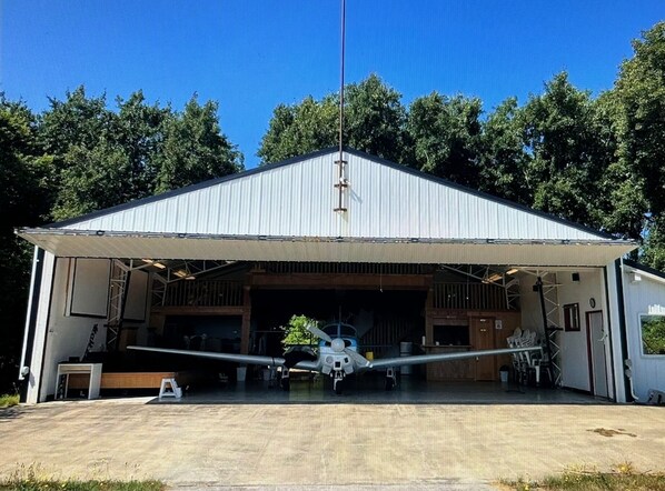 Een hangar met een enkel vliegtuig erin geparkeerd.