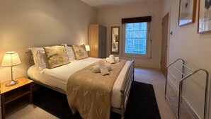 A bedroom with a bed, bedside lamp, wardrobe, window, and a radiator. - fantastic 2 bedroom with secure parking in Edinburgh's New Town (Edinburgh)