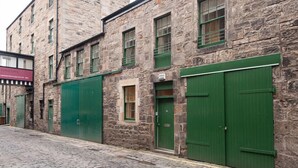 A stone building with green shutters and a signboard. - fantastic 2 bedroom with secure parking in Edinburgh's New Town (Edinburgh)