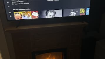 A television displaying YouTube content, including a workout routine and a music video.